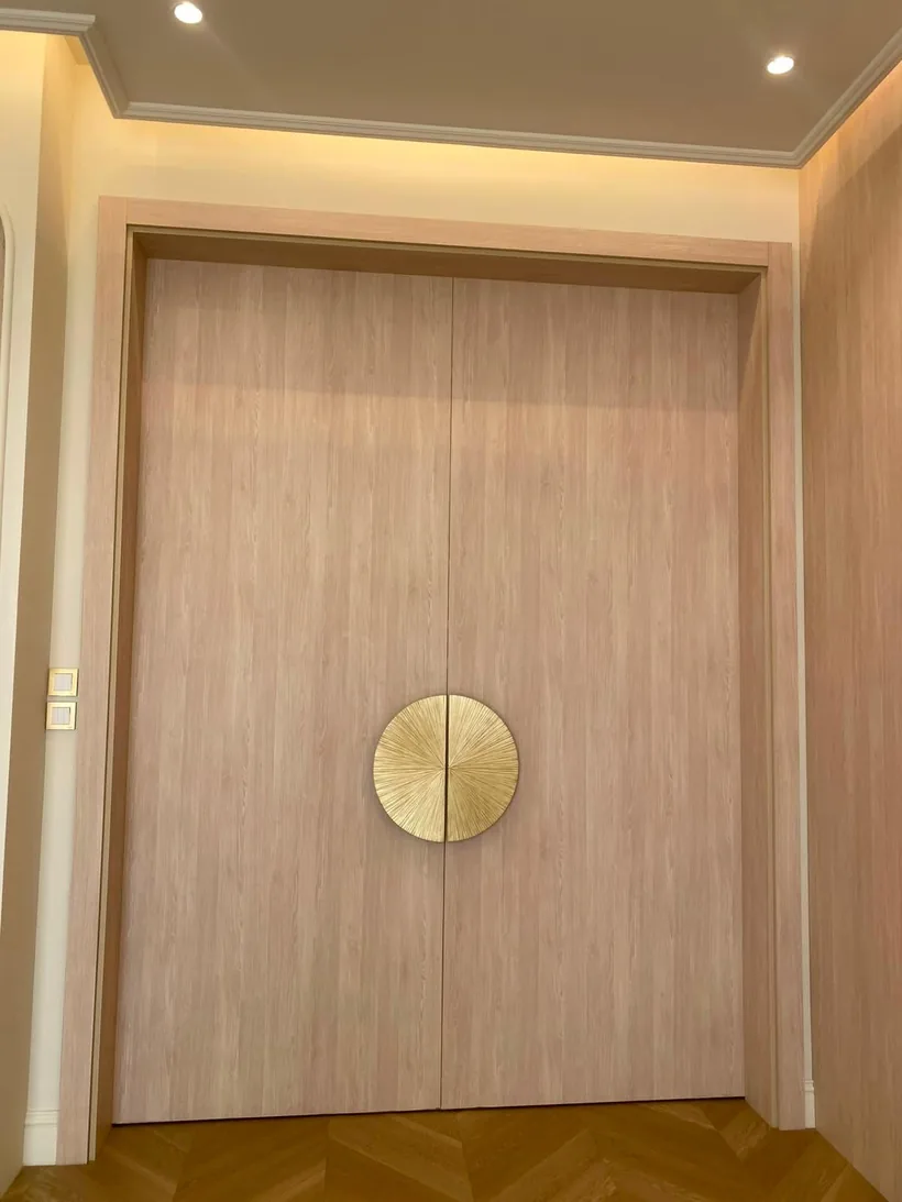 Wood-veneer double door with a round brass handle